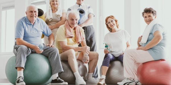 Group,Of,Active,Seniors,Sitting,On,Exercising,Balls,In,Modern