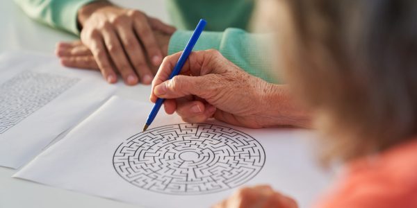 Hand,Of,A,Senior,Citizen,With,Pen,Solving,The,Labyrinth