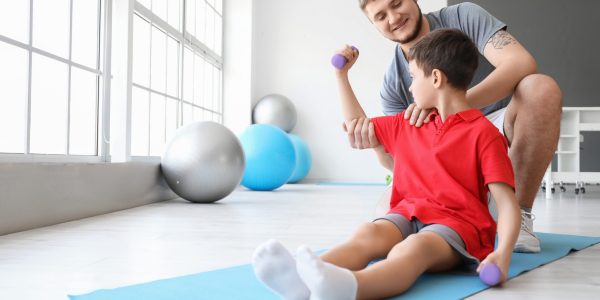 Physiotherapist,Working,With,Boy,In,Rehabilitation,Center