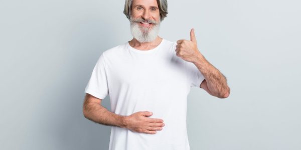 Portrait,Of,Attractive,Cheerful,Gray-haired,Man,Touching,Belly,Showing,Thumbup