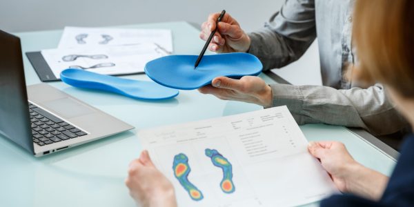 Doctor,Consulting,Patient,On,Custom,Orthotic,Insoles,In,A,Clinic