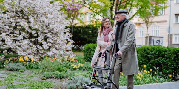 Senior,Man,With,Walking,Frame,And,Adult,Daughter,Outdoors,On