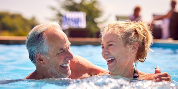 Retired,Senior,Couple,Relaxing,In,Swimming,Pool,On,Summer,Vacation