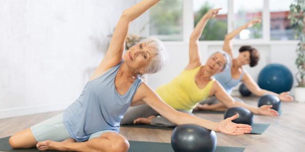 Group,Of,Elderly,Women,Practicing,Pilates,With,Soft,Ball,In