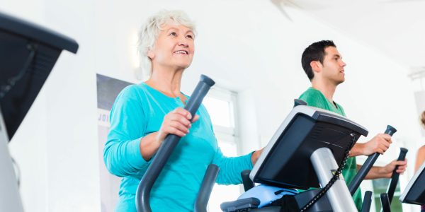 Senior,Woman,On,Elliptical,Trainer,Exercising,In,Gym